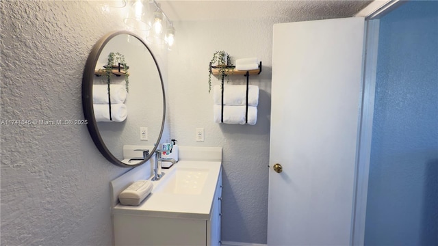 bathroom featuring vanity and a textured wall