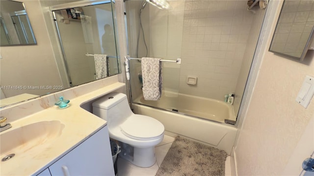 bathroom with vanity, tile patterned floors, toilet, and shower / bath combination with glass door