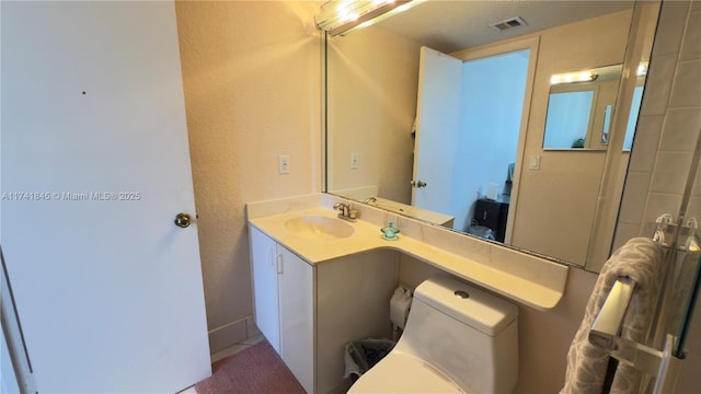 bathroom with visible vents, toilet, and vanity