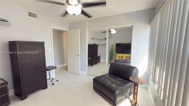 sitting room with visible vents and ceiling fan