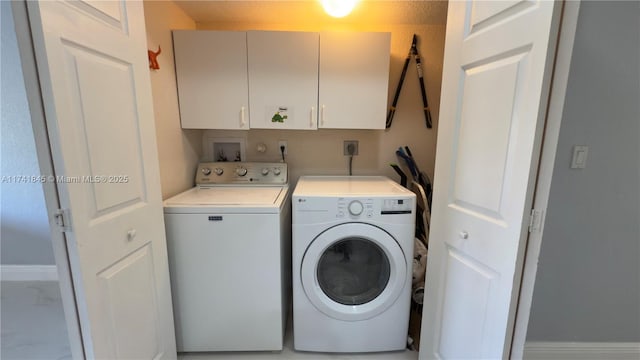 clothes washing area featuring cabinet space and separate washer and dryer