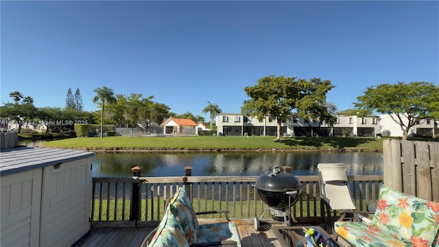 exterior space with a grill, a yard, and a water view