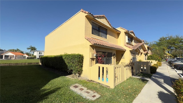 view of home's exterior featuring stucco siding, a yard, and a tiled roof