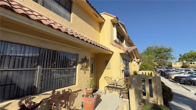 view of home's exterior with a tiled roof and stucco siding