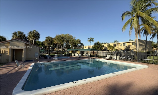 community pool with a patio and fence