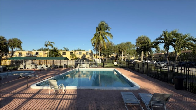 pool with a patio area and fence