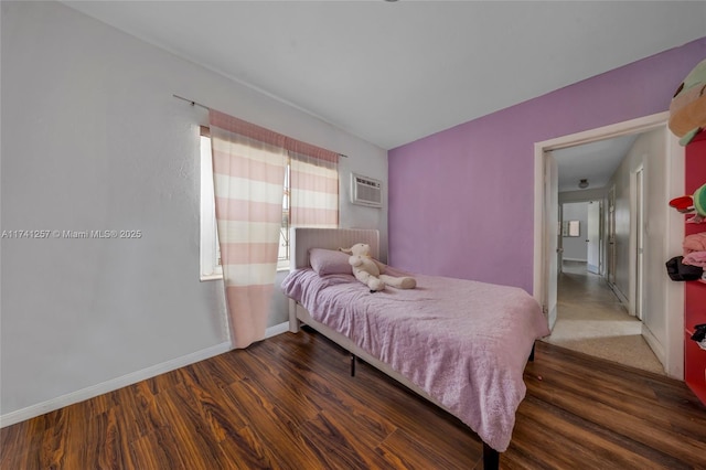 bedroom featuring dark wood-type flooring and a wall unit AC