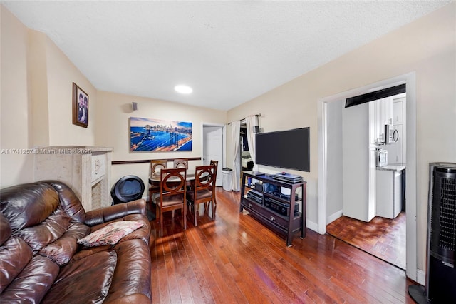 living room featuring hardwood / wood-style flooring, heating unit, and a textured ceiling