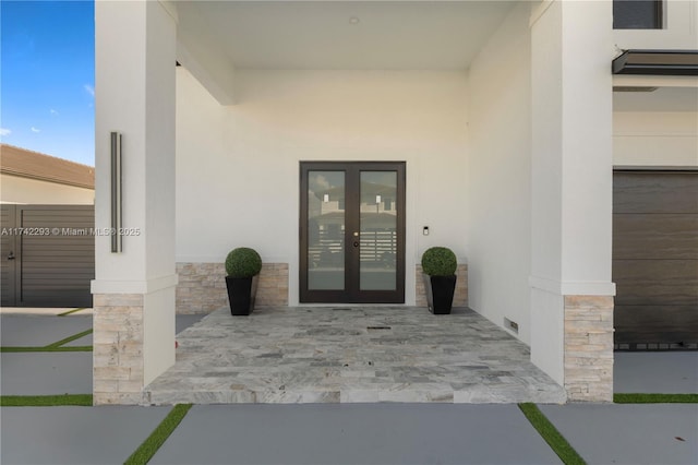 view of exterior entry with a patio and french doors