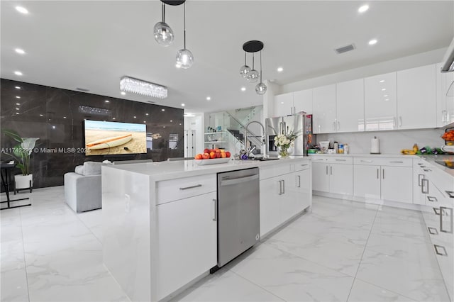 kitchen with white cabinetry, stainless steel appliances, decorative light fixtures, and a kitchen island