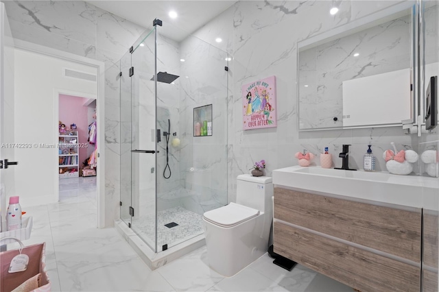 bathroom with vanity, toilet, a shower with door, and tile walls