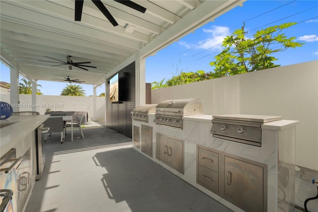 view of patio / terrace with ceiling fan, a grill, and exterior kitchen