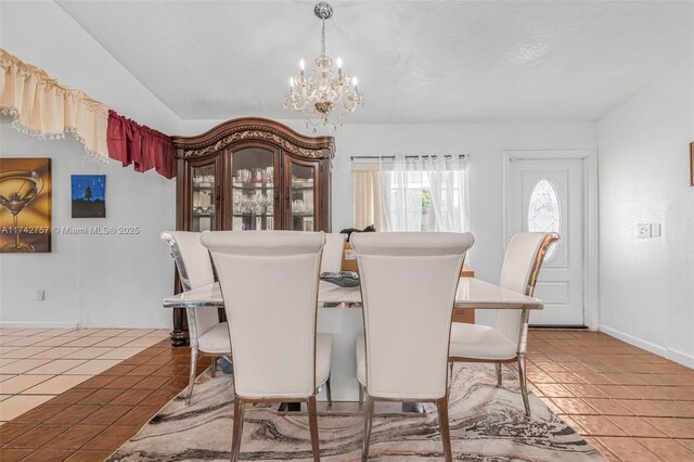 dining room with tile patterned floors, a chandelier, and a textured ceiling