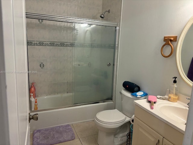 full bathroom featuring vanity, tile patterned floors, shower / bath combination with glass door, and toilet