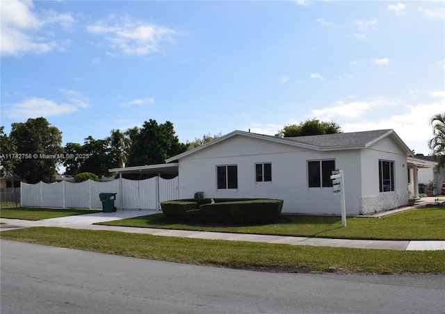 view of home's exterior featuring a lawn and fence