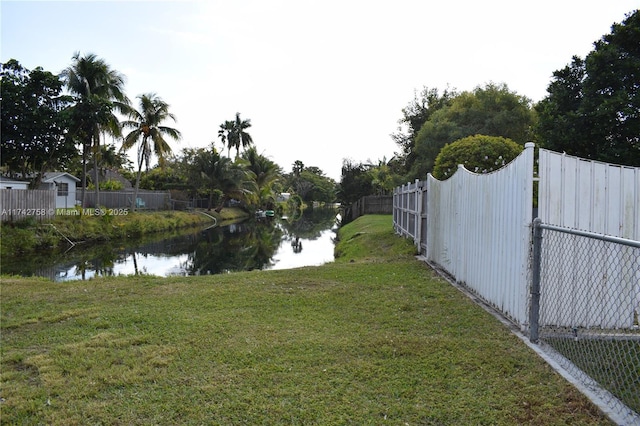 view of yard with fence and a water view