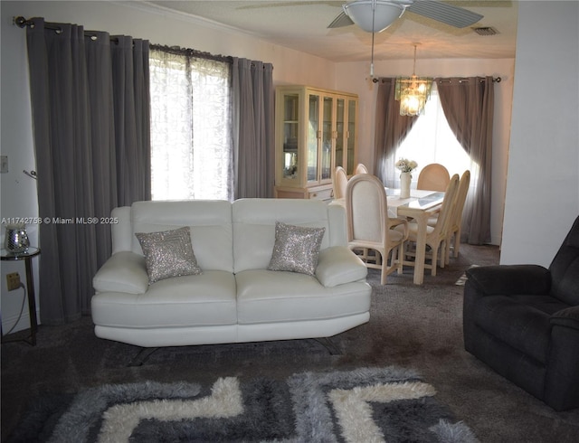 living area with visible vents, carpet floors, and a ceiling fan