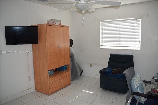 sitting room featuring light tile patterned floors, baseboards, and a ceiling fan