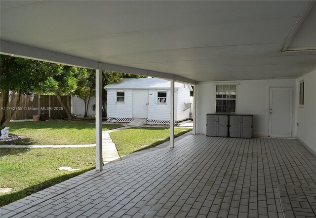 view of patio / terrace with a storage unit, an outdoor structure, and fence