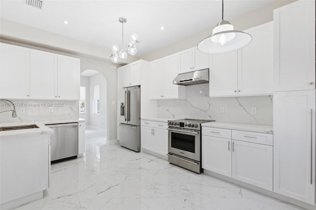 kitchen featuring pendant lighting, white cabinetry, sink, decorative backsplash, and stainless steel appliances