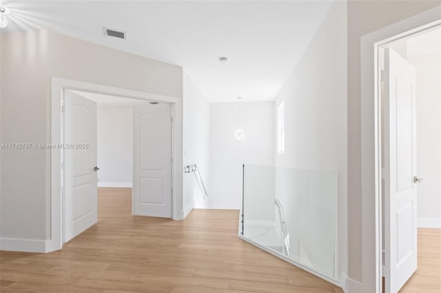 corridor with light hardwood / wood-style floors