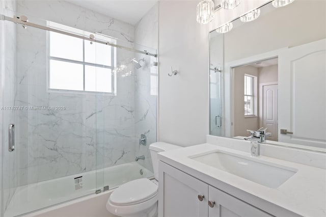 full bathroom featuring vanity, shower / bath combination with glass door, and toilet