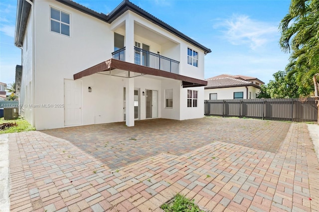 rear view of house featuring central AC, a balcony, and a patio area