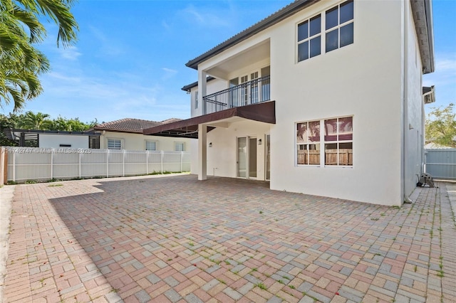 back of house with a balcony and a patio area