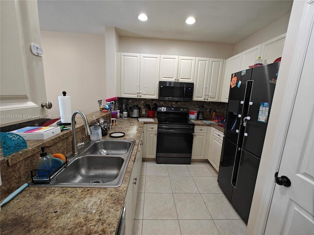 kitchen with tasteful backsplash, sink, white cabinets, light tile patterned floors, and black appliances