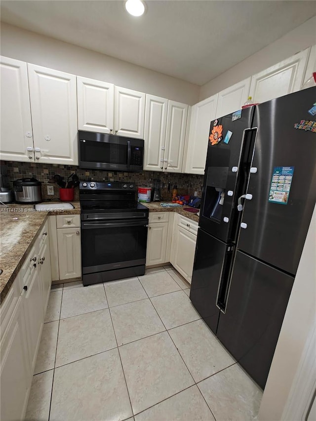 kitchen with white cabinetry, backsplash, and black appliances