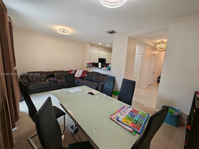 dining area featuring a textured ceiling and light tile patterned flooring