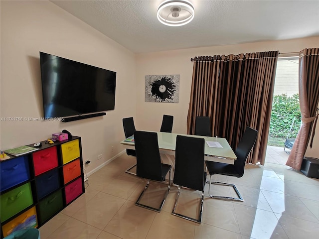 tiled dining room featuring a textured ceiling