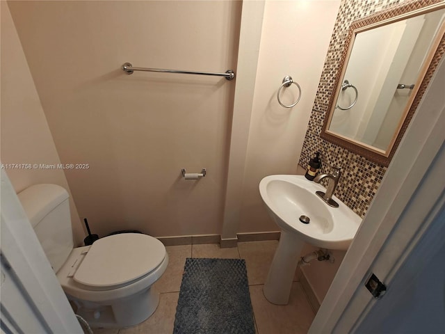 bathroom featuring tasteful backsplash, sink, tile patterned flooring, and toilet