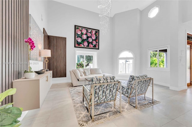 living room featuring an inviting chandelier and a towering ceiling