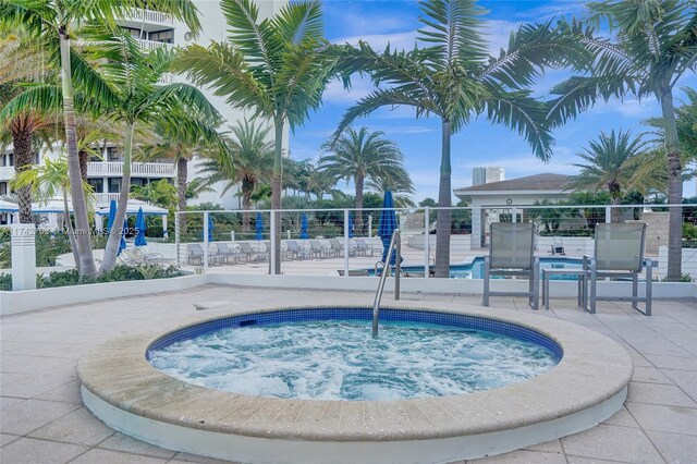 view of pool featuring a community hot tub and a patio