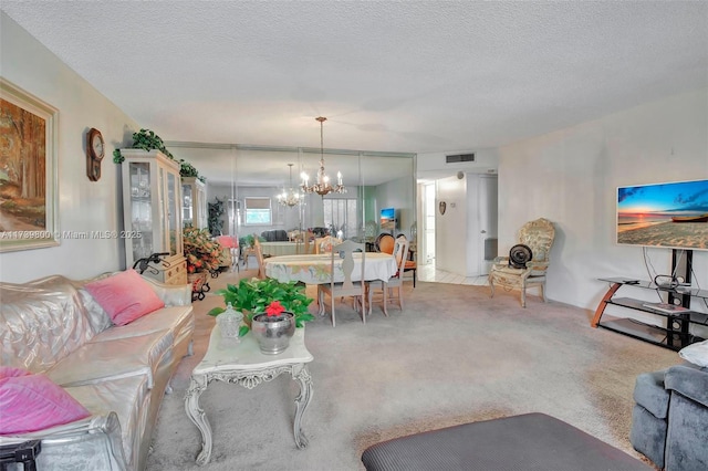 living room featuring a textured ceiling, light colored carpet, and a chandelier