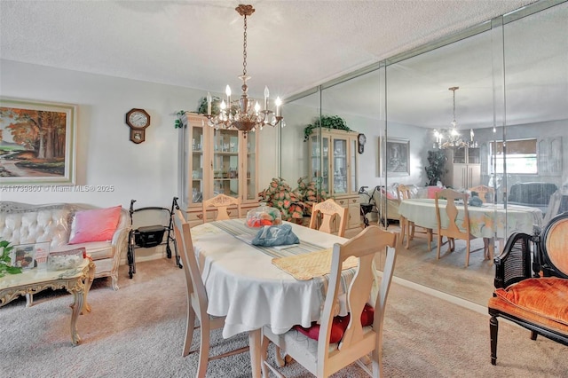 carpeted dining area with a chandelier and a textured ceiling