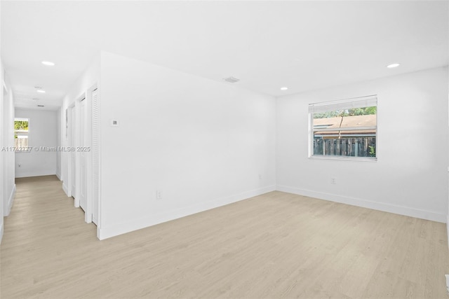 empty room with light hardwood / wood-style flooring and a healthy amount of sunlight