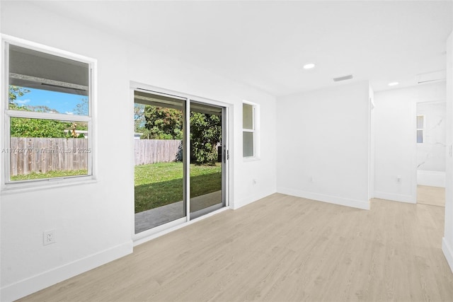 unfurnished room featuring plenty of natural light and light wood-type flooring