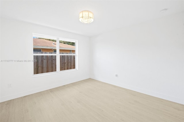 unfurnished room featuring hardwood / wood-style floors and a notable chandelier