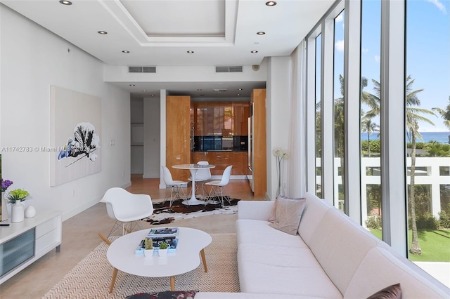 living room featuring a tray ceiling and plenty of natural light