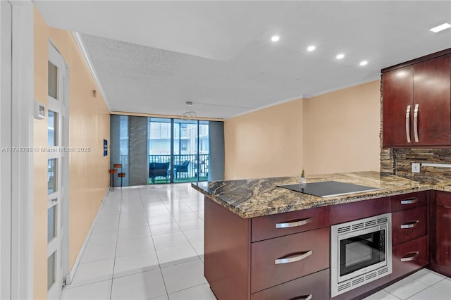 kitchen featuring stainless steel microwave, black electric stovetop, and kitchen peninsula