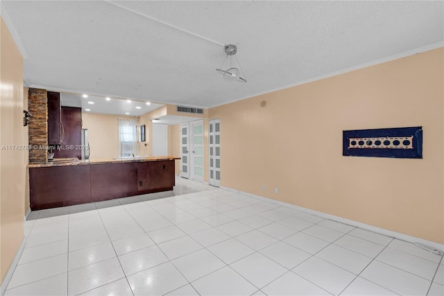 interior space featuring light tile patterned floors, crown molding, and a textured ceiling