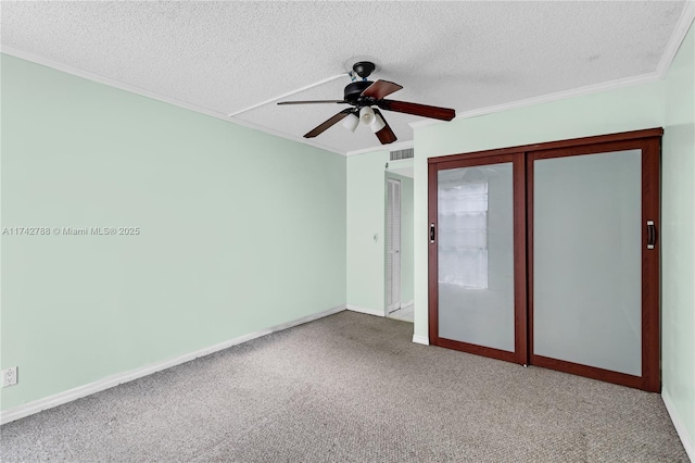 unfurnished bedroom featuring ornamental molding, carpet flooring, ceiling fan, and a textured ceiling