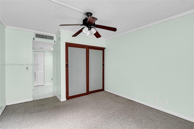 unfurnished bedroom featuring ornamental molding, light carpet, a textured ceiling, and a closet