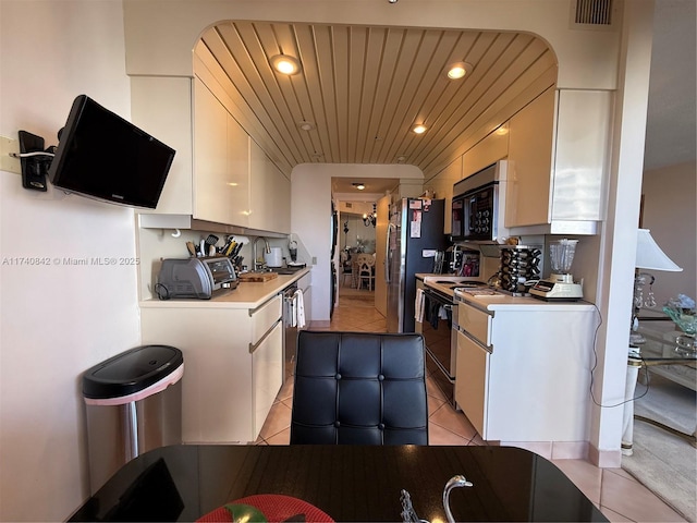 kitchen featuring range with electric stovetop, sink, white cabinets, light tile patterned floors, and wooden ceiling