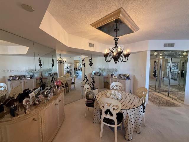 dining area featuring a textured ceiling and a chandelier