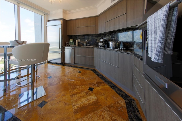 kitchen featuring tasteful backsplash, sink, built in refrigerator, stainless steel dishwasher, and crown molding