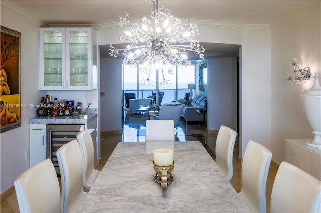 dining room featuring an inviting chandelier, crown molding, beverage cooler, and indoor bar