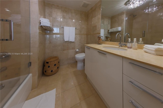 bathroom featuring tile patterned flooring, vanity, tile walls, and toilet